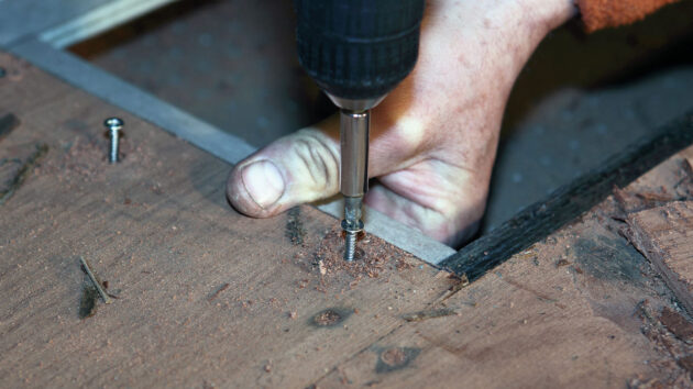 Wooden cleats being screwed into a coachroof of a boat ahead of epoxy sheathing