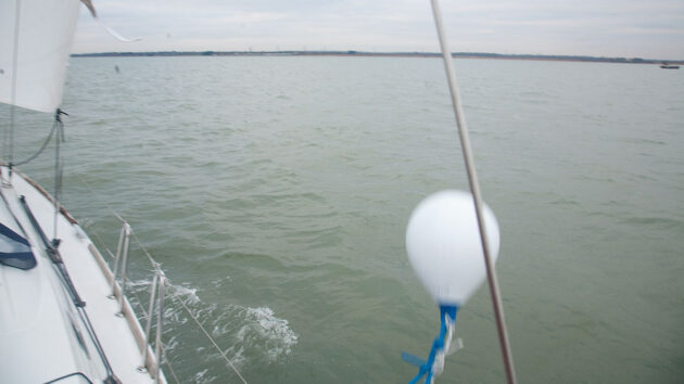 A buoy being thrown into the water from a boat