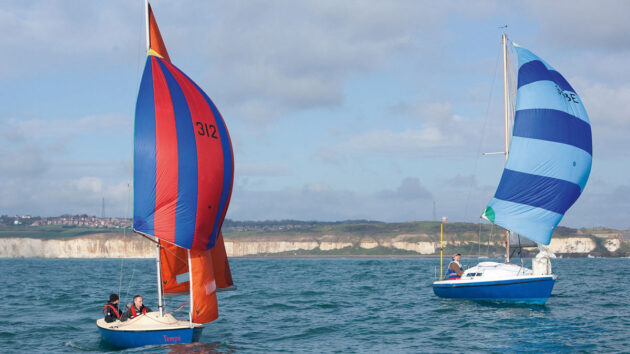 Two boats racing - one has a masthed rig