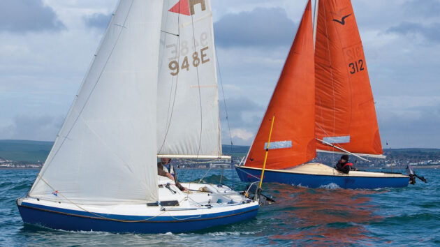 Two boats racing side by side - one has a masthead rig