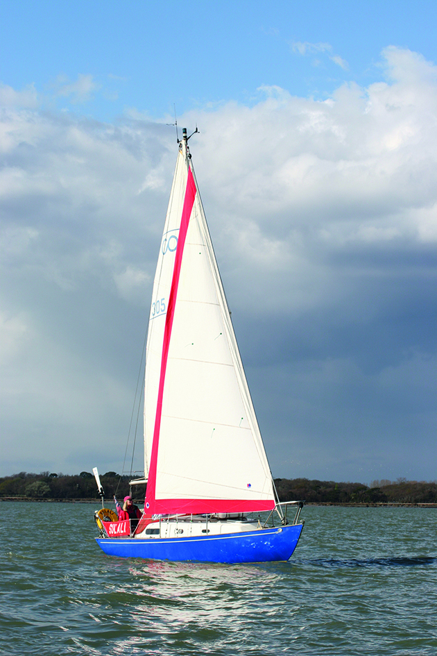 A Contessa 26 sailing under a cloud sky