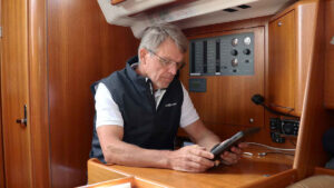 Knut Frostad looking at a tablet on a boat