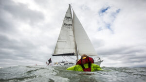 a man overboard on the water with the yacht in the background