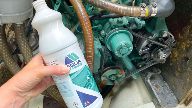 A person applying bilge cleaner to their boat to make improvements to the smell