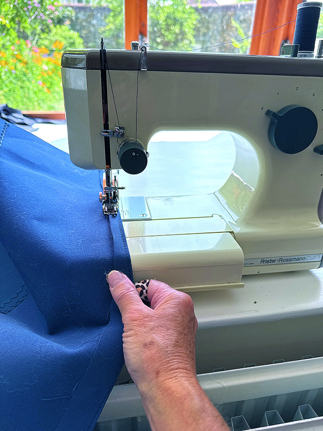 A woman sewing canvas on a sewing machine