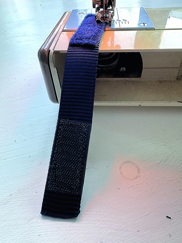 Velcro straps being sewn on a sewing machine