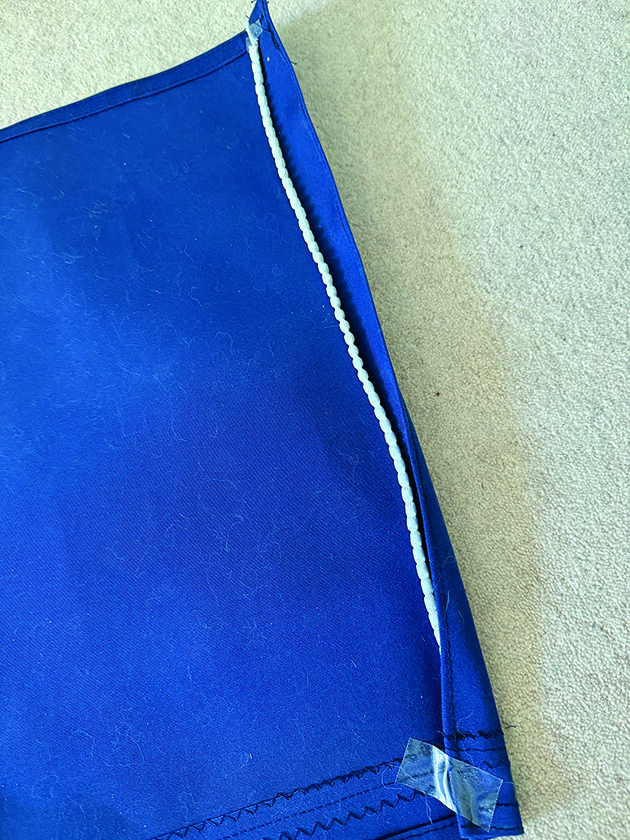 A weighted hem being sewn into a companionway cover