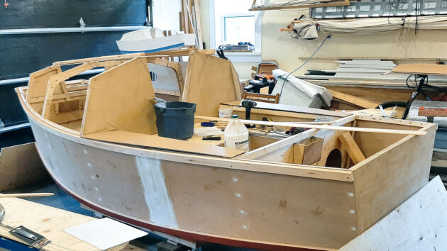 A trailer-sailer boat being built in a workshop