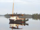 A man rowing a trailer-sailer on a lake