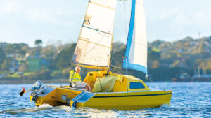 A man sailing a yellow Chat 18 catamaran