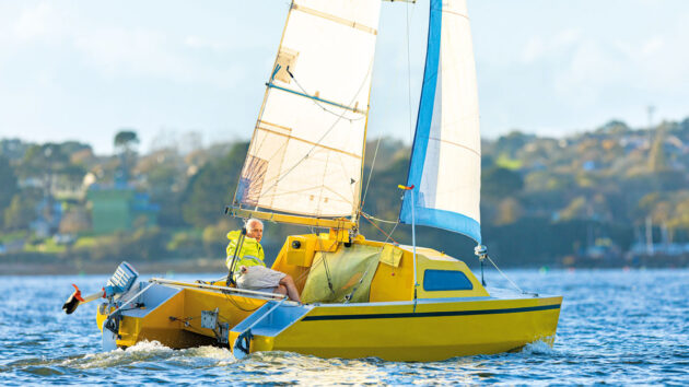 A man sailing a yellow Chat 18 catamaran