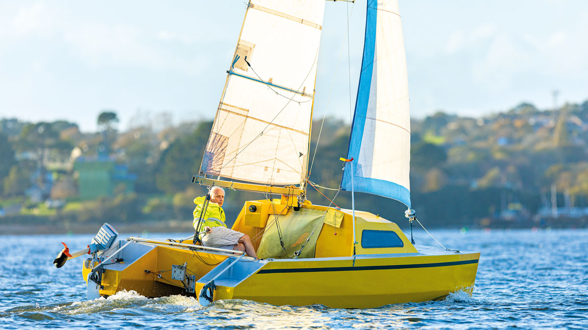 A man sailing a yellow Chat 18 catamaran