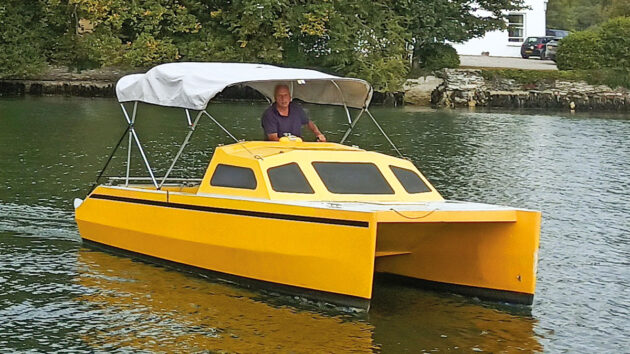 A yellow motor cat with a white bimini