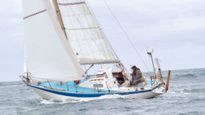 A yacht sailing out to sea. There is a vhf ais antenna on the boat