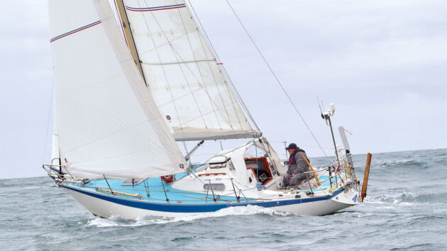 A yacht sailing out to sea. There is a vhf ais antenna on the boat