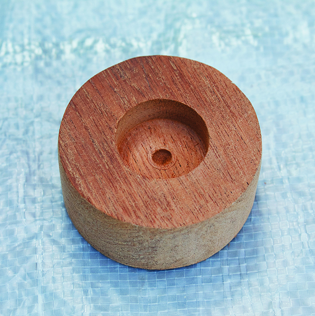 A drilled button top out of wood for the top of a wooden ensign flagstaff