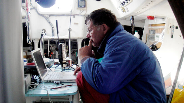 A man looking at a lap top on a boat