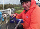 A man repairing a yacht mast and furler