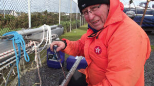 A man repairing a yacht mast and furler