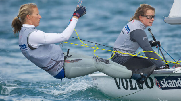 Olympic sailors Saskia and Hannah Mills dinghy sailing, wearing Volvo and Skandia GBR sponsor branded team gear. Credit: Peter Llewellyn/Alamy