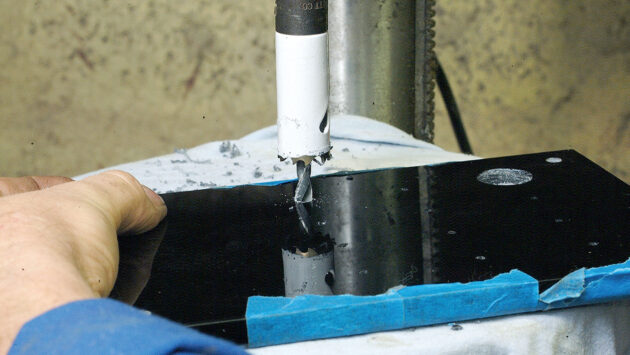A man making a perspex switch panel for a boat