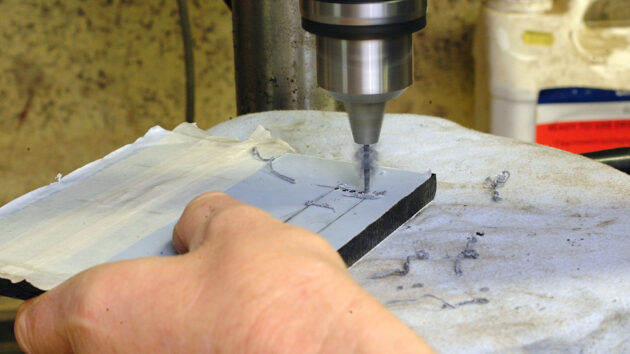 A man making a perspex switch panel for a boat