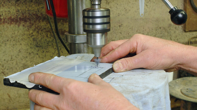 A man making a perspex switch panel for a boat