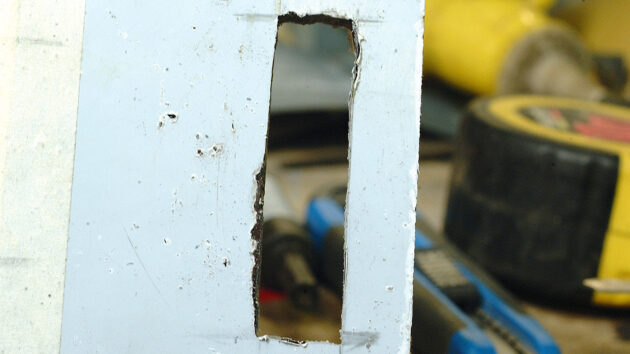 A man making a perspex switch panel for a boat