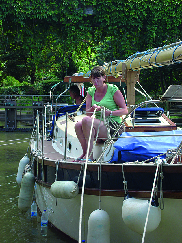 A woman preparing lines on a boat before entering a canal lock
