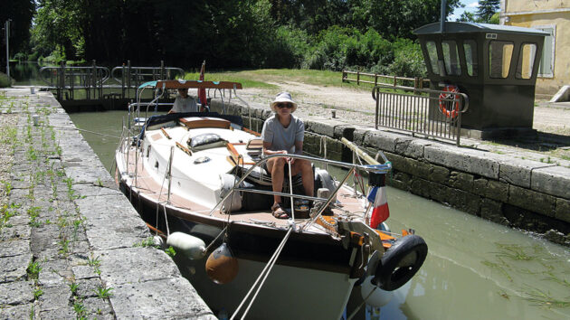 A woman preparing rope on a boat before heading into a canal lock