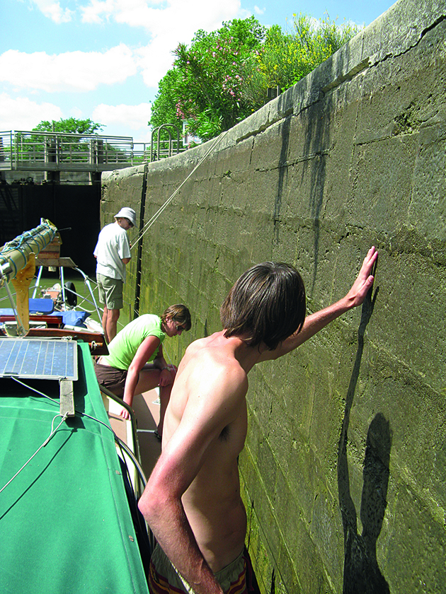People helping to move a boat through canal locks
