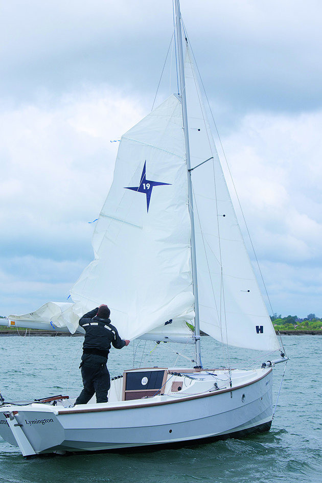 A man sailing a small white boat