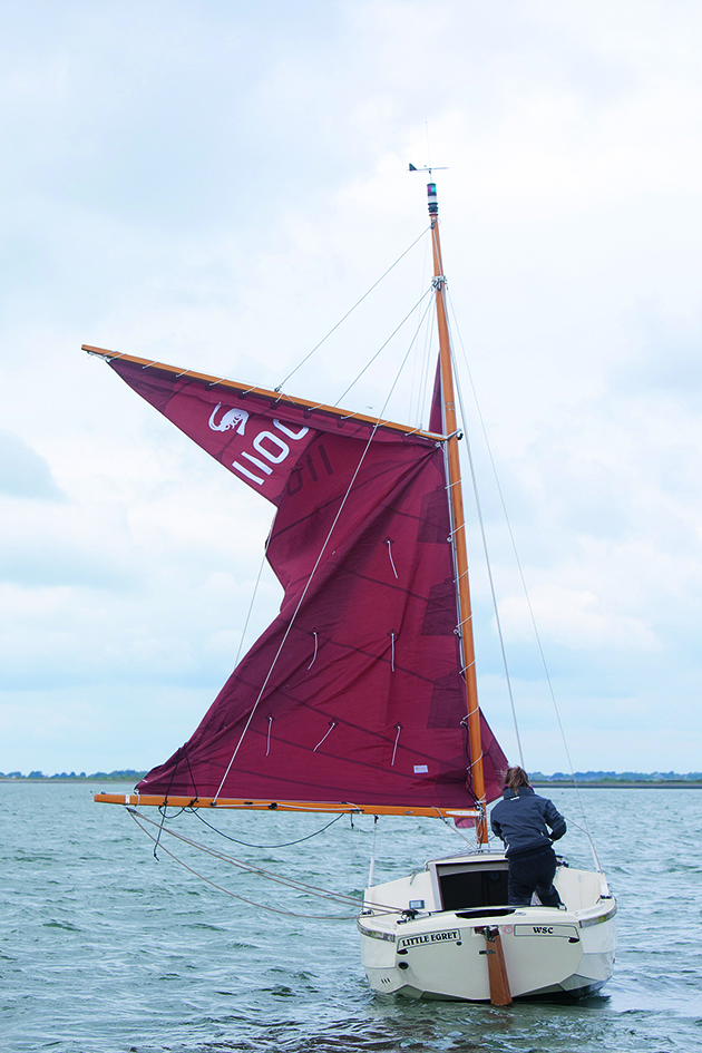 Gaff rigs: a man hoisting the main sail on a gaff-rigged boat