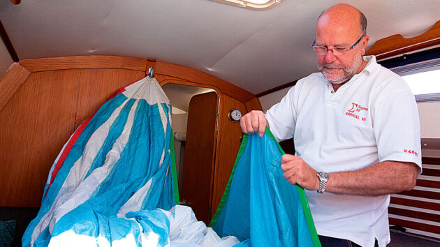 A man showing how to pack up a spinnaker while sailing short-handed