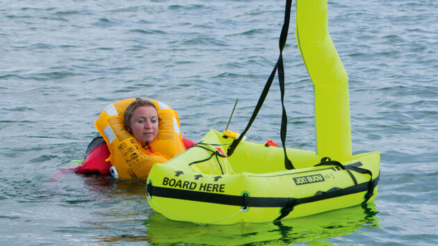 A woman swimming towards a deployed Jon Buoy