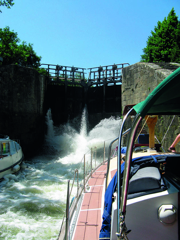 A yacht and its crew demonstrating how to use canal locks
