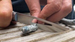 A man using an Opinel no 9 ocean knife for cutting rope