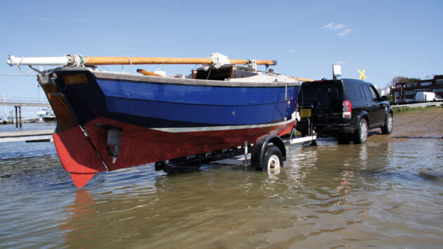 Two men launching a boat on a slipway