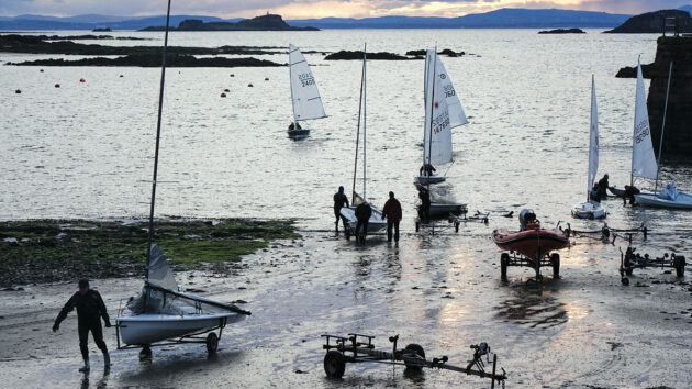 Dinghy sailors pulling their boats ashore