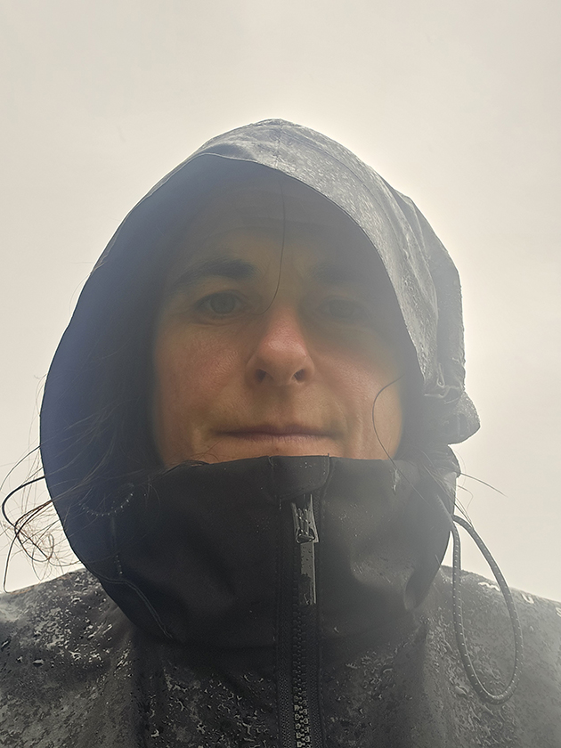 A woman wearing the Musto EVO Crew jacket while it is raining