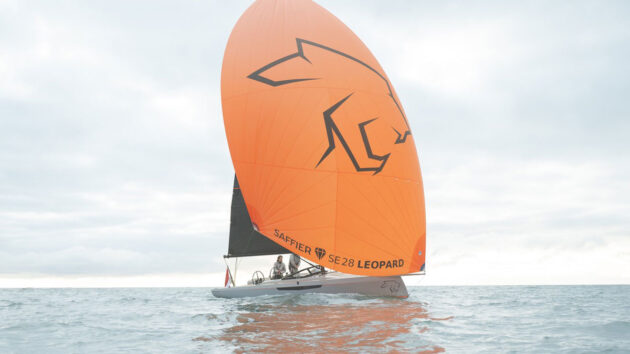 A yacht with an orange sail 