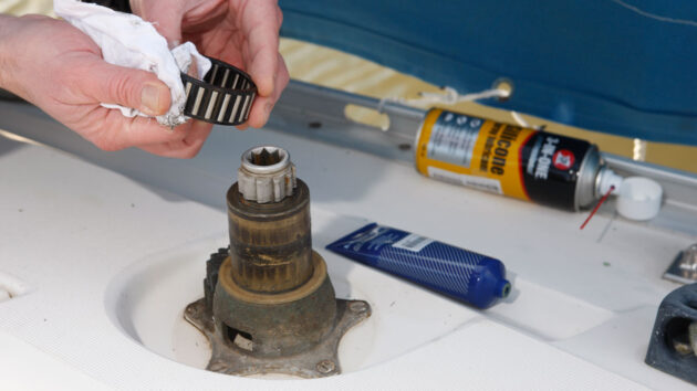 A person servicing a winch on a boat