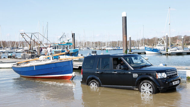A man launching a boat with a 4x4 and a trailer