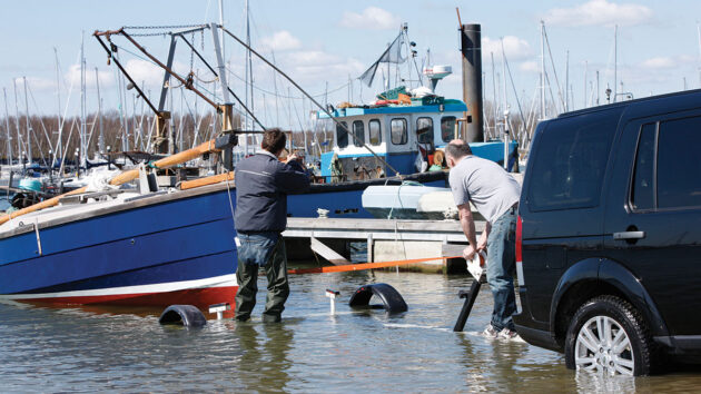 Two men manoeuvring a boat onto a trailer