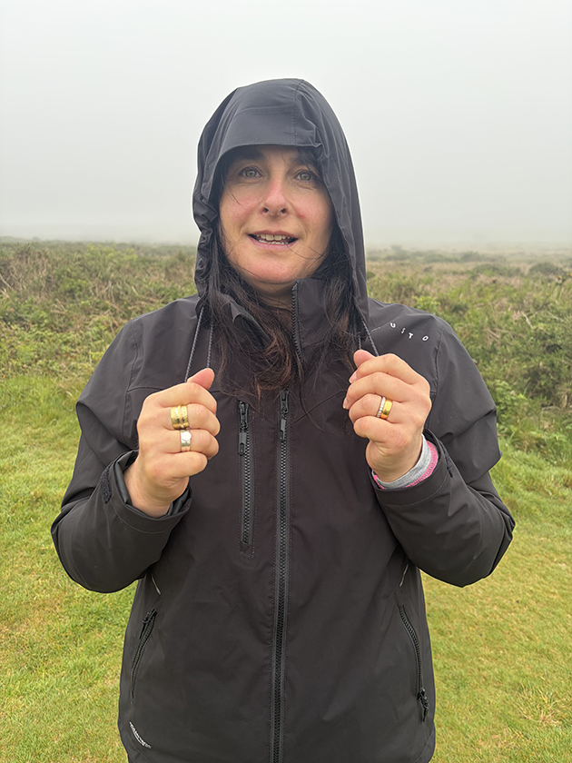 A woman wearing the Musto EVO Crew jacket while it is raining