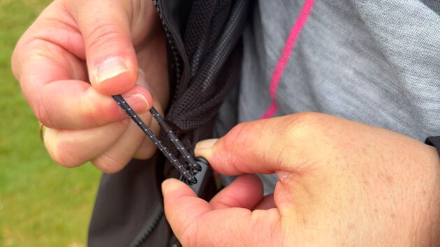 A woman wearing the Musto EVO Crew jacket while it is raining