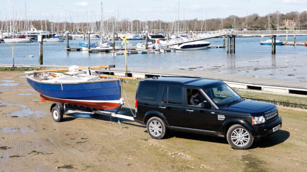 A man launching a boat using a 4x4 and trailer