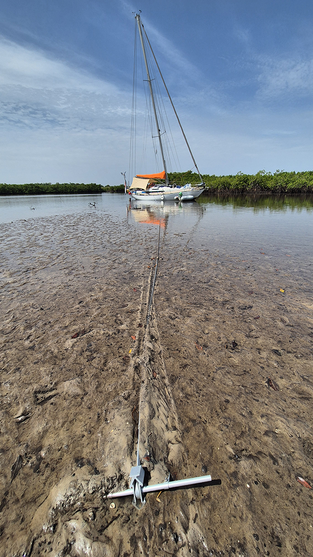 A careening boat held by a kedge anchor in a river