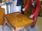 A man marine varnishing a chart table for a yacht
