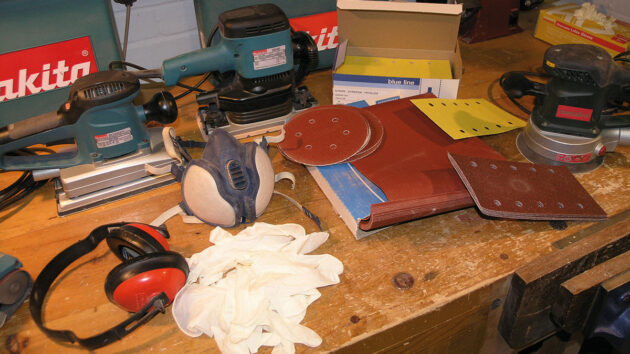 A selection of abrasives, electric sanders and safety gear for marine varnishing
